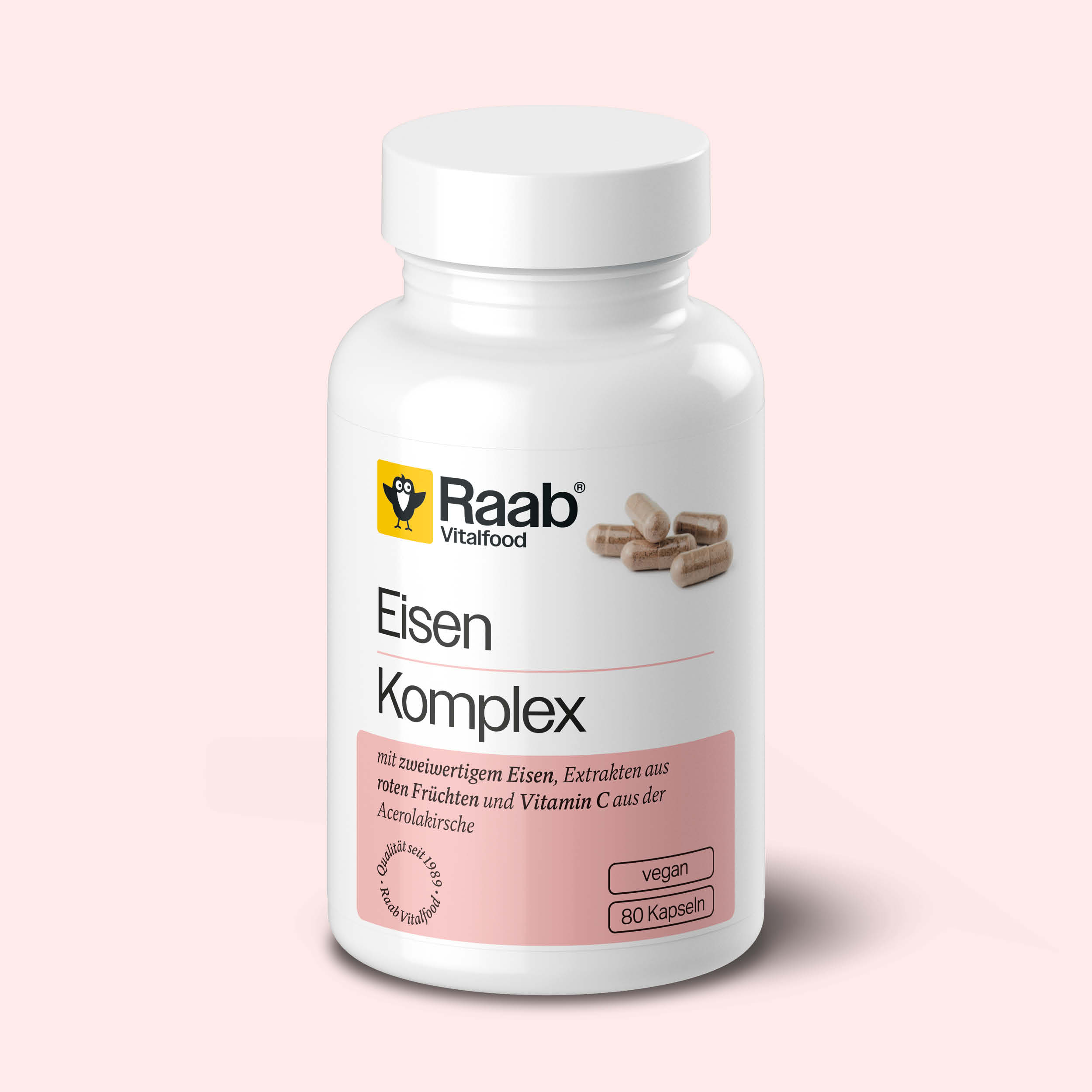 Dose Raab Vitalfood Eisen Komplex mit 80 veganen Kapseln, mit zweiwertigem Eisen, Vitamin C und Fruchtextrakten, auf rosa Hintergrund.